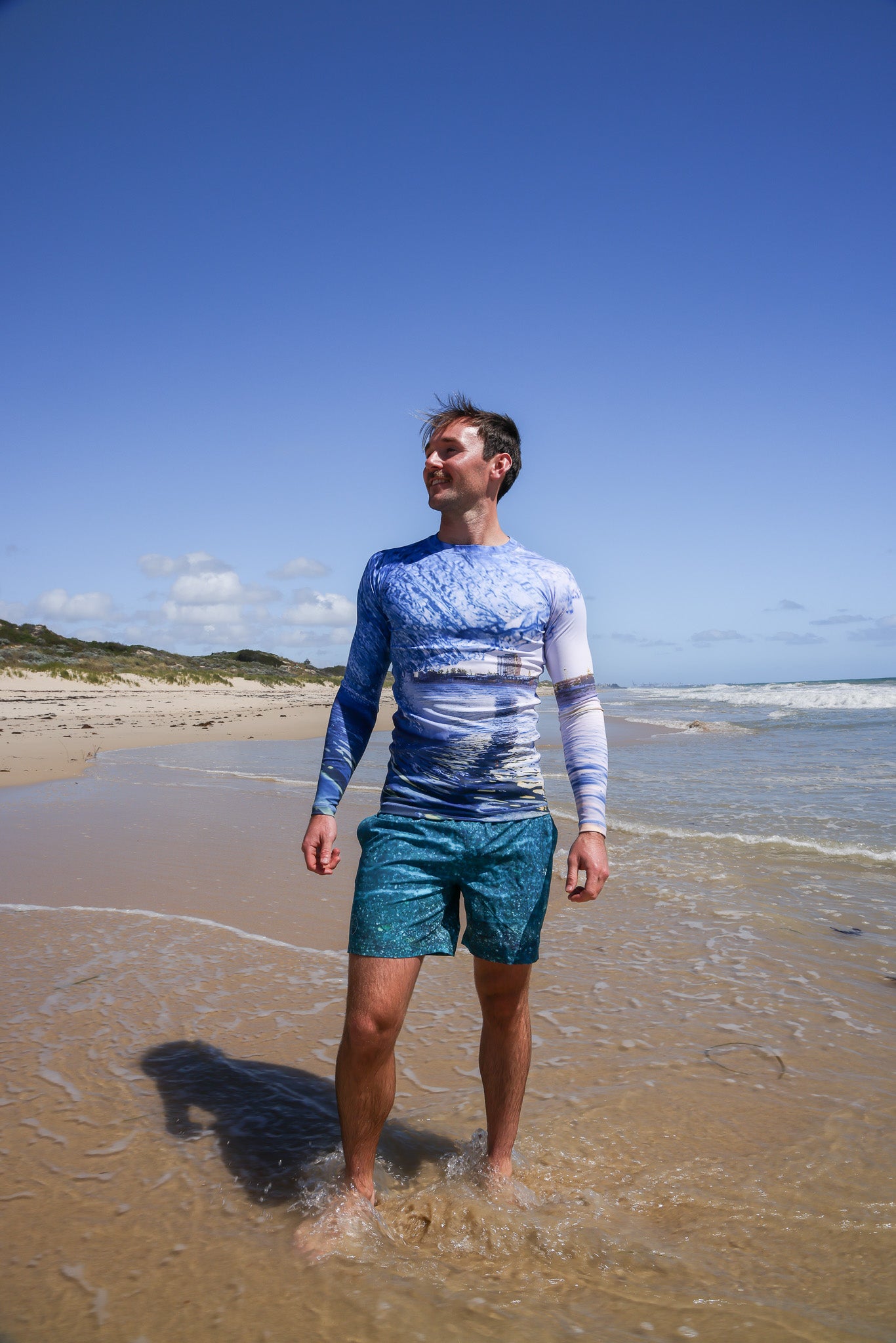 Model wearing rashie printed with a photo of Scarborough beach, Perth - front